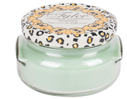 A green Tyler Candle Company jar candle with a decorative lid featuring a leopard print design.