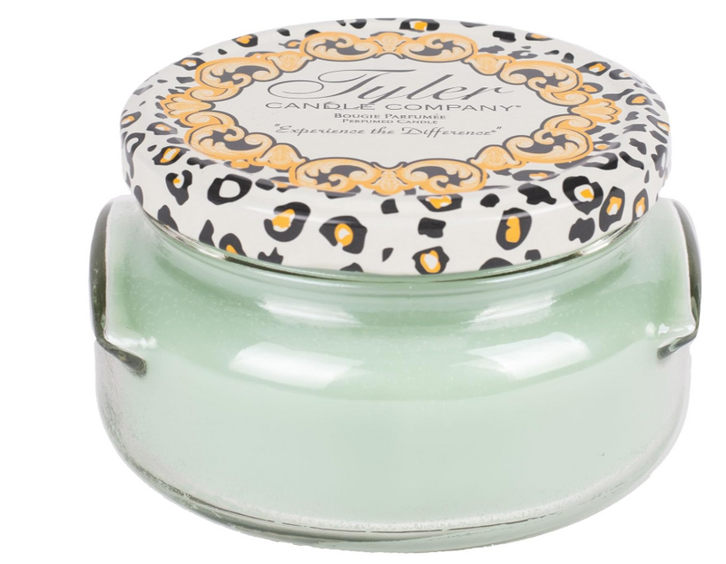 A green Tyler Candle Company jar candle with a decorative lid featuring a leopard print design.