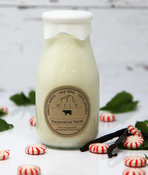 Scented candle labeled 'Peppermint Twist' with peppermint candies and vanilla beans on a light background