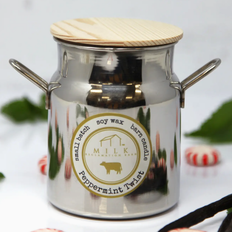 Metallic candle jar with wooden lid and 'Milk and Honey' label on a white background