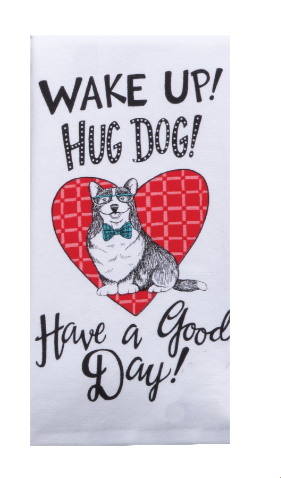 Towel with a dog illustration and text 'Wake up! Hug dog! Have a good day!' on a white background