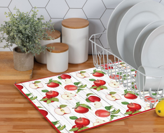 Kitchen scene with a placemat featuring apple pattern on a wooden floor.