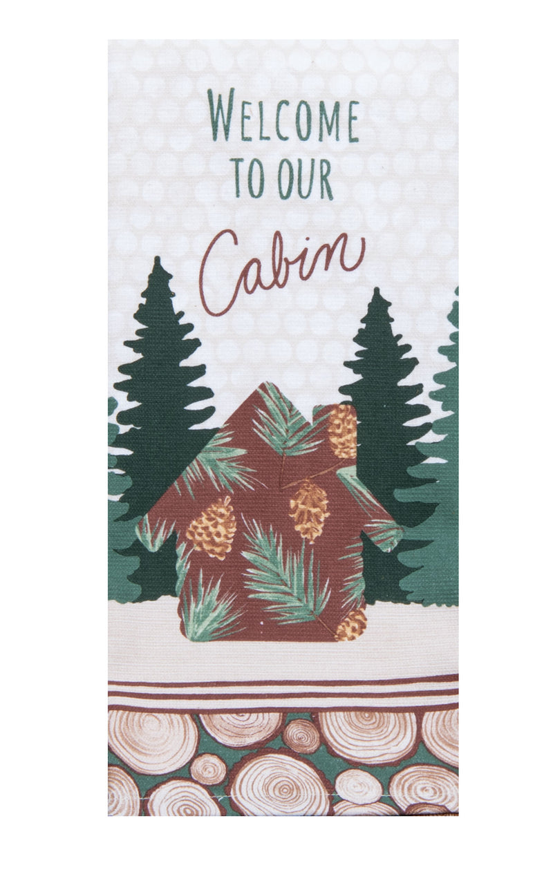 A vertical decorative tea towel with the words 'WELCOME TO OUR Cabin' above an illustrated cabin with pine trees and wood-slice patterning at the bottom.