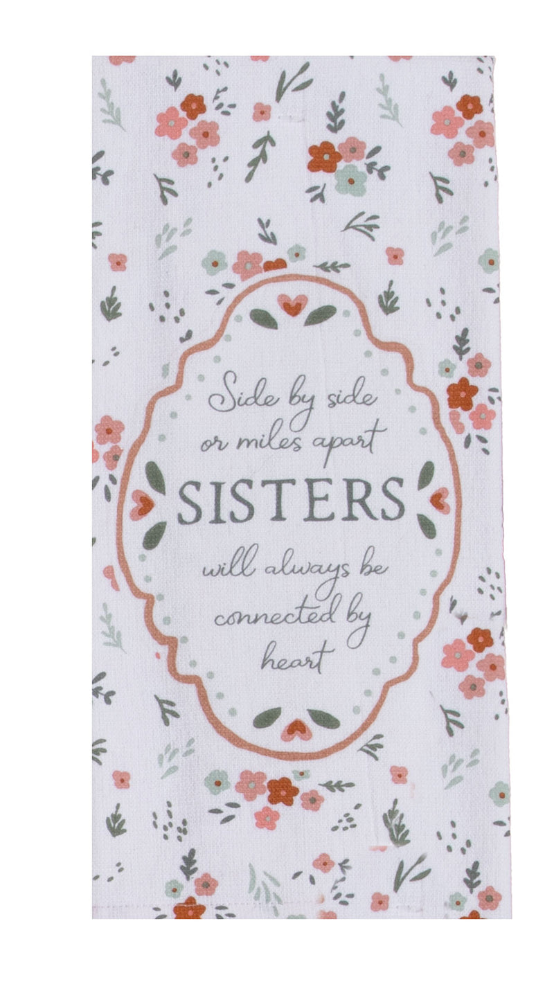 A rectangular white kitchen towel with a delicate floral border and a central decorative frame containing the text, 'Side by side or miles apart SISTERS will always be connected by heart'.