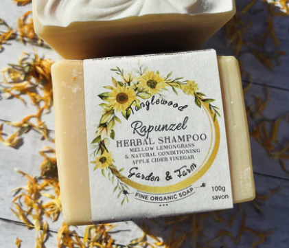 Bar of soap with a decorative label featuring sunflowers on a wooden surface.