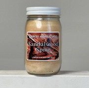 Jar of Sandalwood Spice candle with a label on a gray background