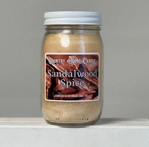 Jar of Sandalwood Spice candle with a label on a gray background