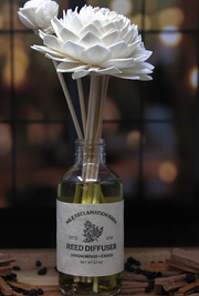 Reed diffuser with white flowers and blurred background