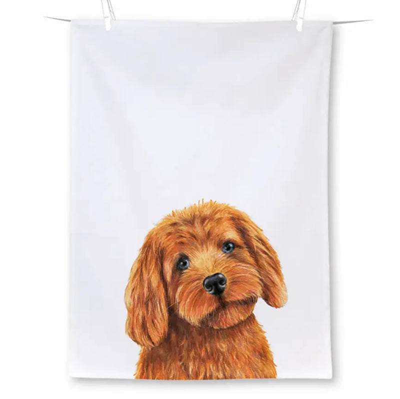 A white fabric tea towel with a detailed illustration of a fluffy reddish-brown dog, shown hanging from clips against a white background.