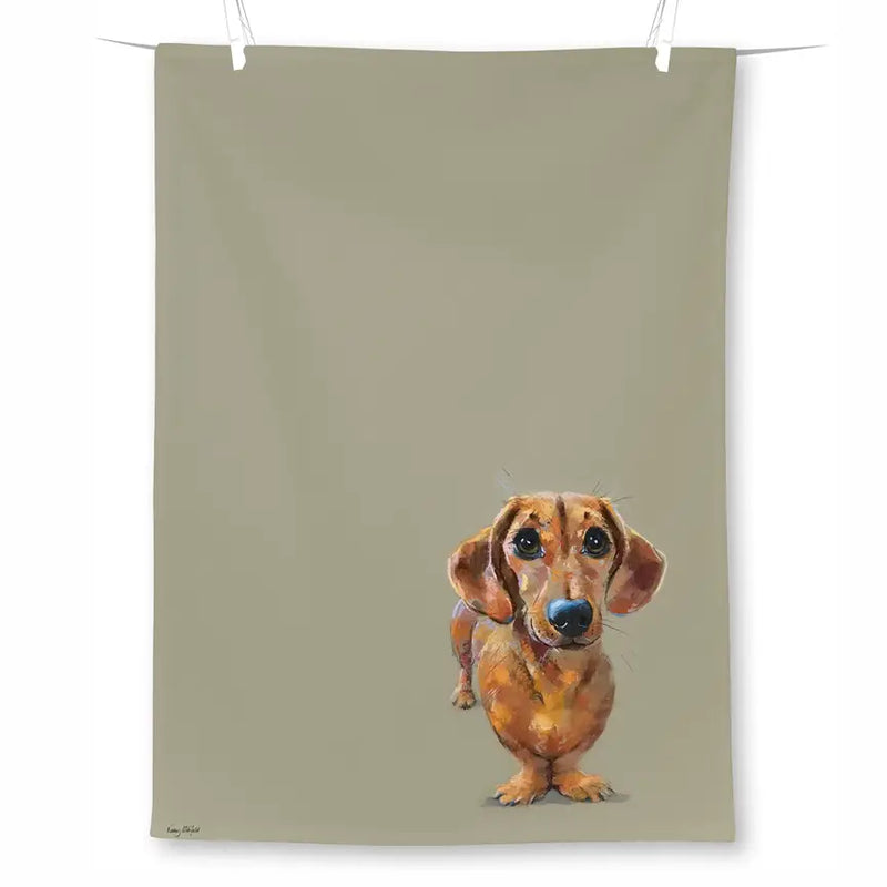 A rectangular tea towel in warm taupe, featuring a printed dachshund dog near the lower center.