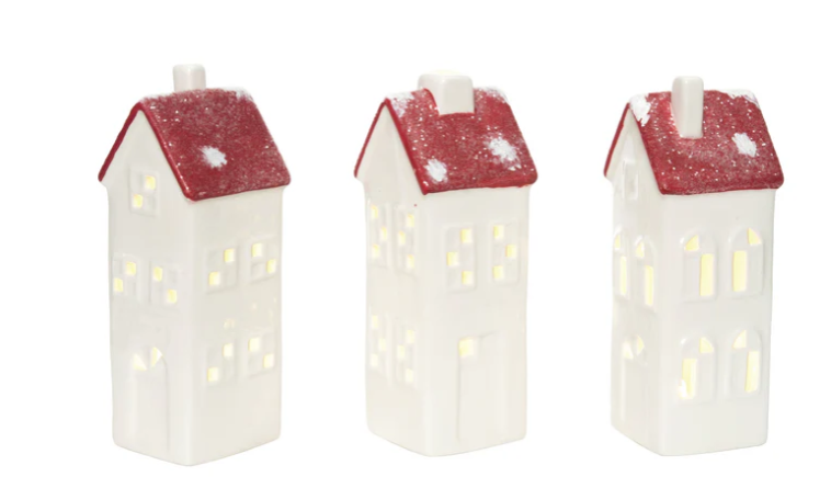 Three house-shaped candles with red roofs on a white background