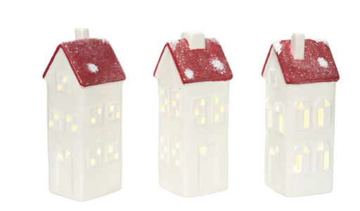 Three house-shaped candles with red roofs on a white background