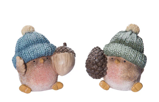 Two small figurines resembling birds wearing knitted hats on a white background