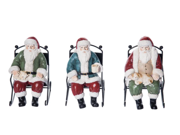 Three Santa Claus figurines sitting on chairs with a white background