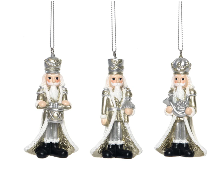Three decorative nutcracker ornaments on a white background
