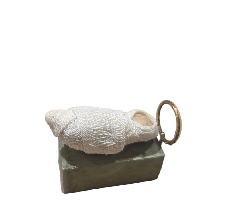 Decorative shell on a green stone base with a gold ring