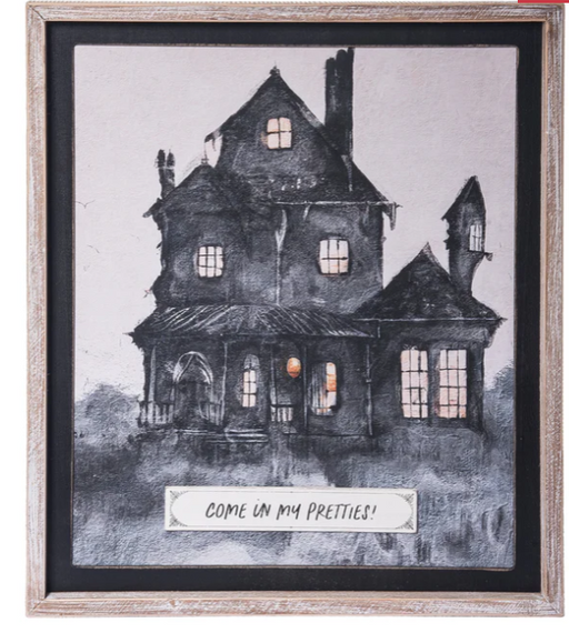 Framed artwork of a haunted house with a text overlay on a light background