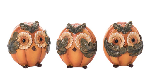 Three decorative pumpkins with owl faces on a white background