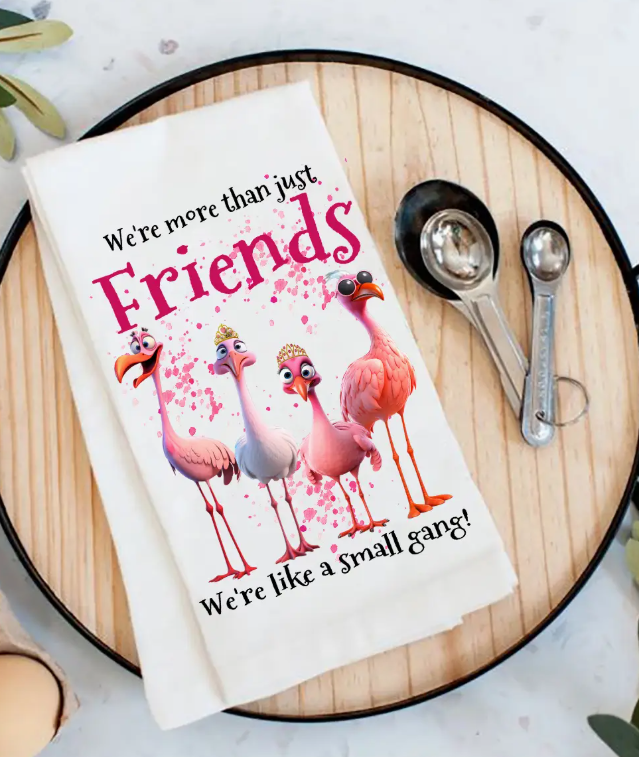 Floral-themed towel with flamingo design and text on a wooden surface