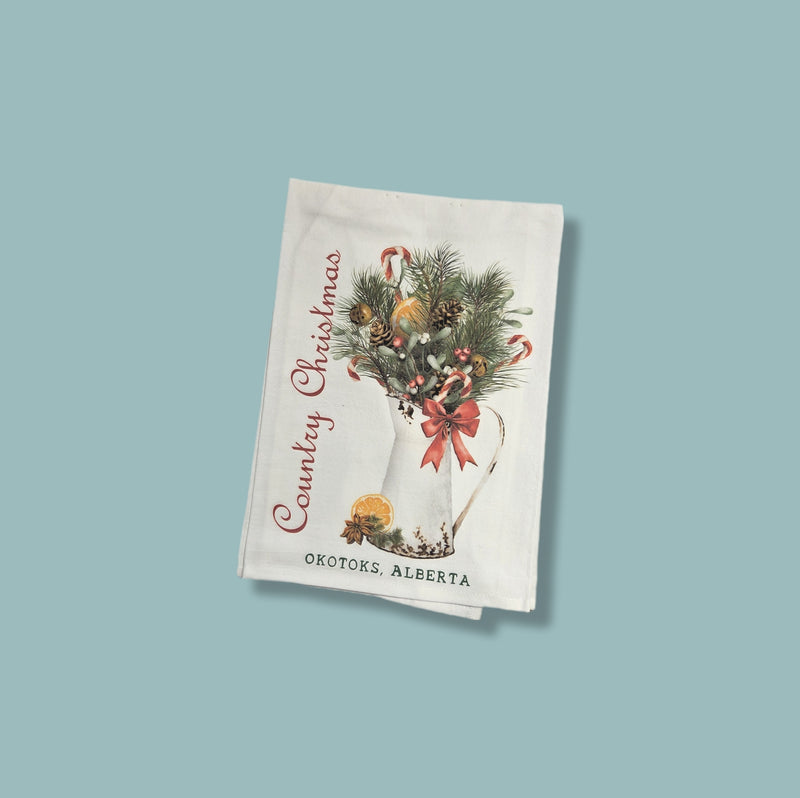 Decorative towel with Christmas design and text on a light blue background