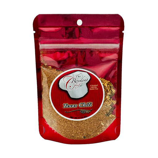 Red package of 'The Resident Chef' Texas Chili with visible chili powder inside.