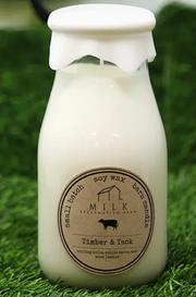 Soy wax candle in a bottle with a label on a grassy background