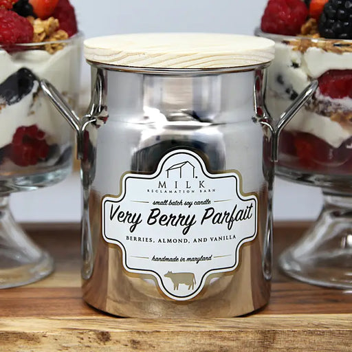 Metallic candle jar labeled 'Very Berry Parfait' with dessert in the background