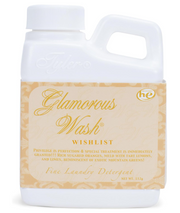 A white bottle of 'Glamorous Wash' laundry detergent with elegant gold and beige labeling.