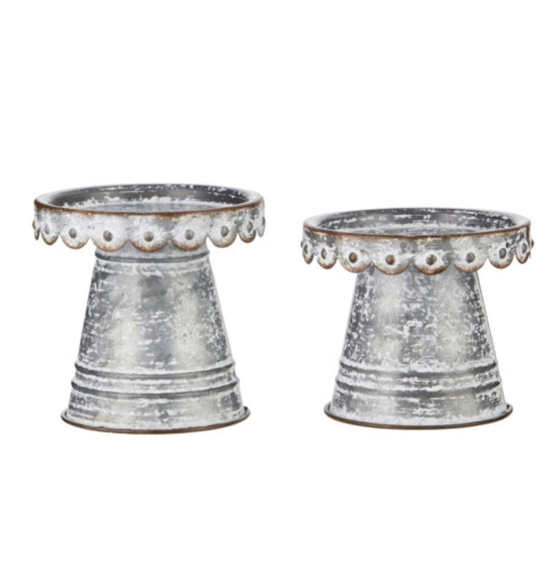 Two decorative metal planters with textured surface and decorative rim on a white background