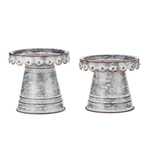 Two decorative metal planters with textured surface and decorative rim on a white background