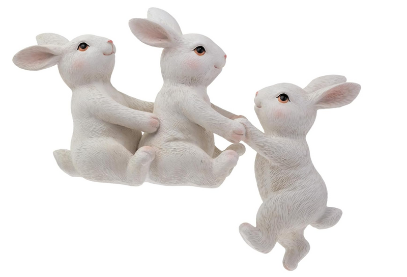 Three white rabbit figurines holding hands on a white background