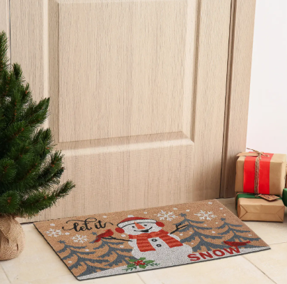 Christmas-themed doormat with a snowman design in front of a wooden door.