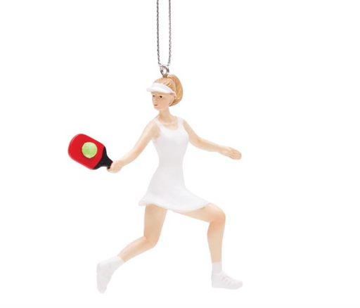 A resin ornament featuring a woman playing pickleball, dressed in a white outfit and holding a red paddle, suspended by a string.