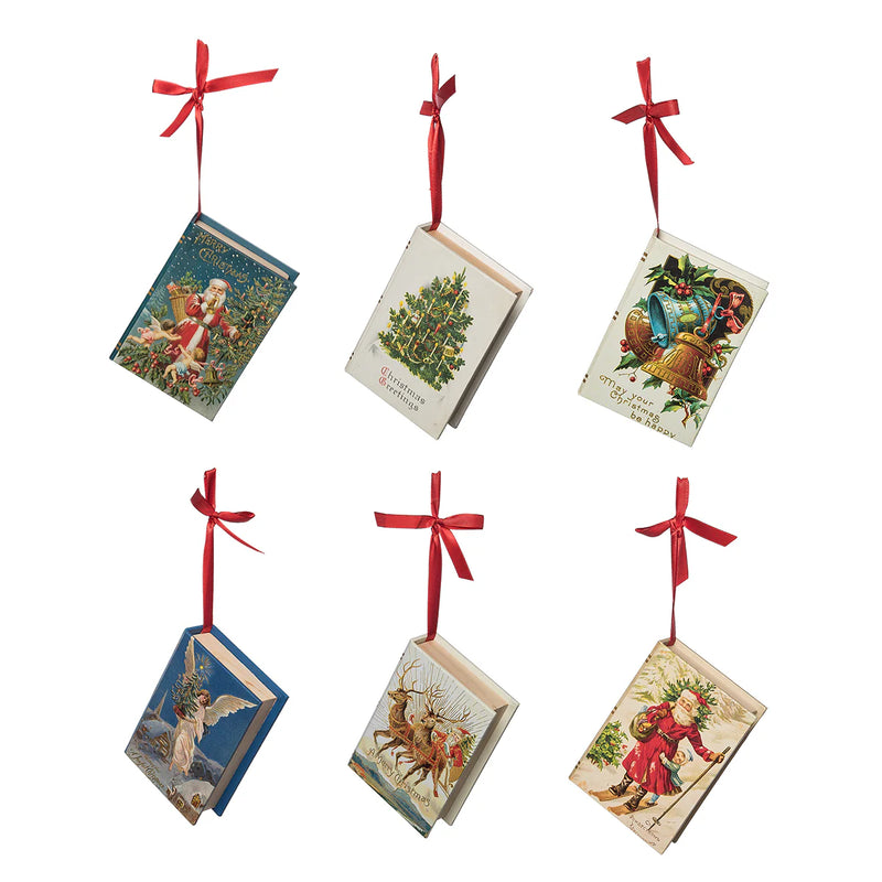 Set of six Christmas-themed book ornaments with red ribbons on a white background
