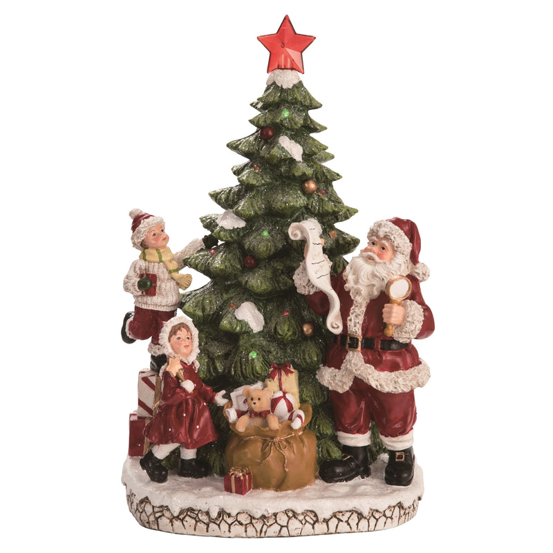 Decorative figurine of Santa Claus and children around a Christmas tree with a red star on top.