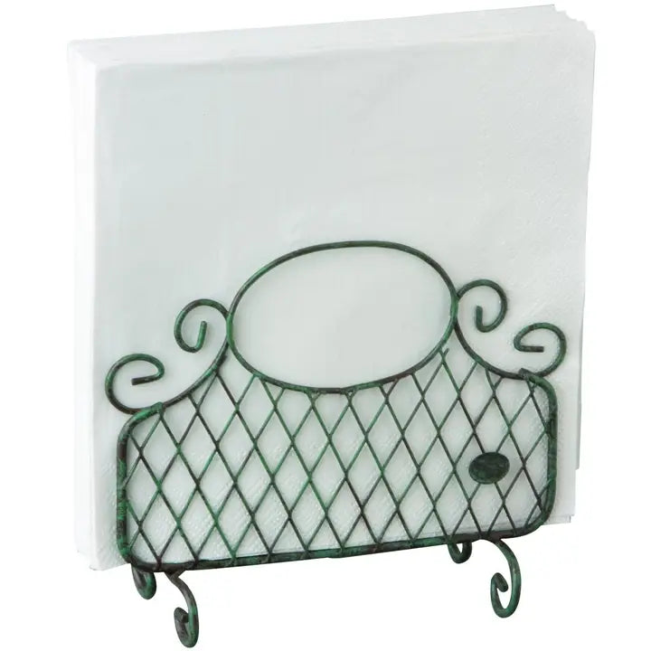 A green metal wire napkin holder with an ornate scroll design, holding a stack of white paper napkins against a plain white background.