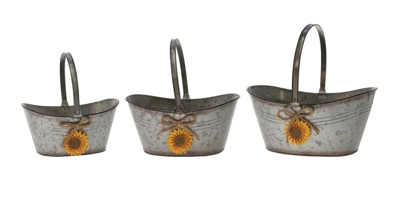 Three metal flower pots with sunflower designs on a white background