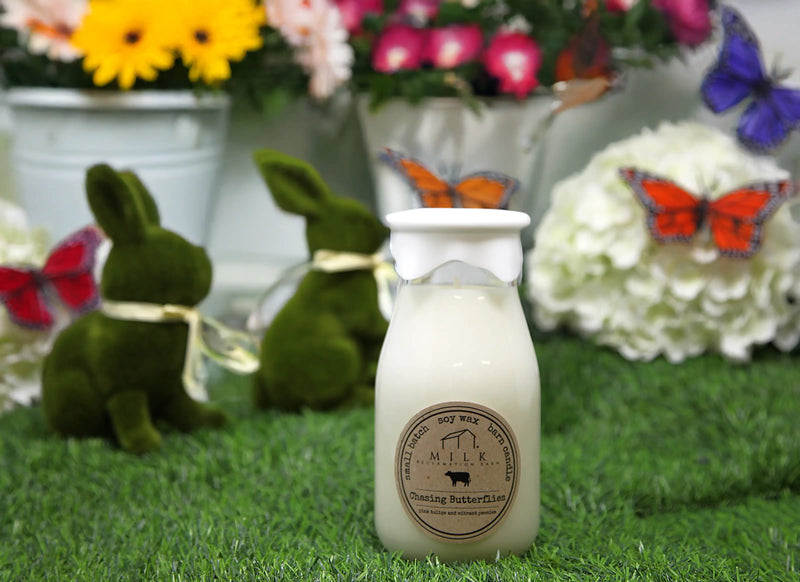 Small bottle labeled 'Butterfly Farm' on grass with decorative elements like flowers and butterflies.