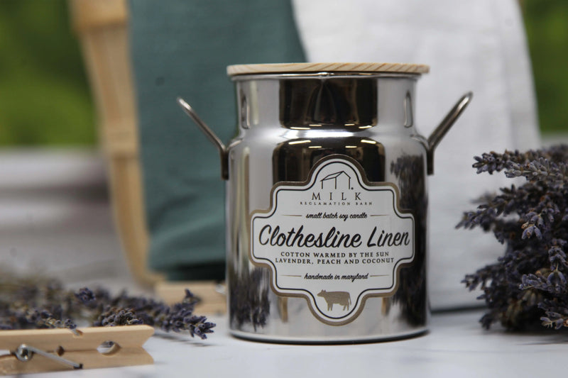Silver candle jar with a label on a surface with lavender flowers