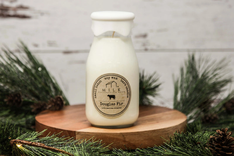 Milk bottle candle on a wooden stand with Christmas decorations