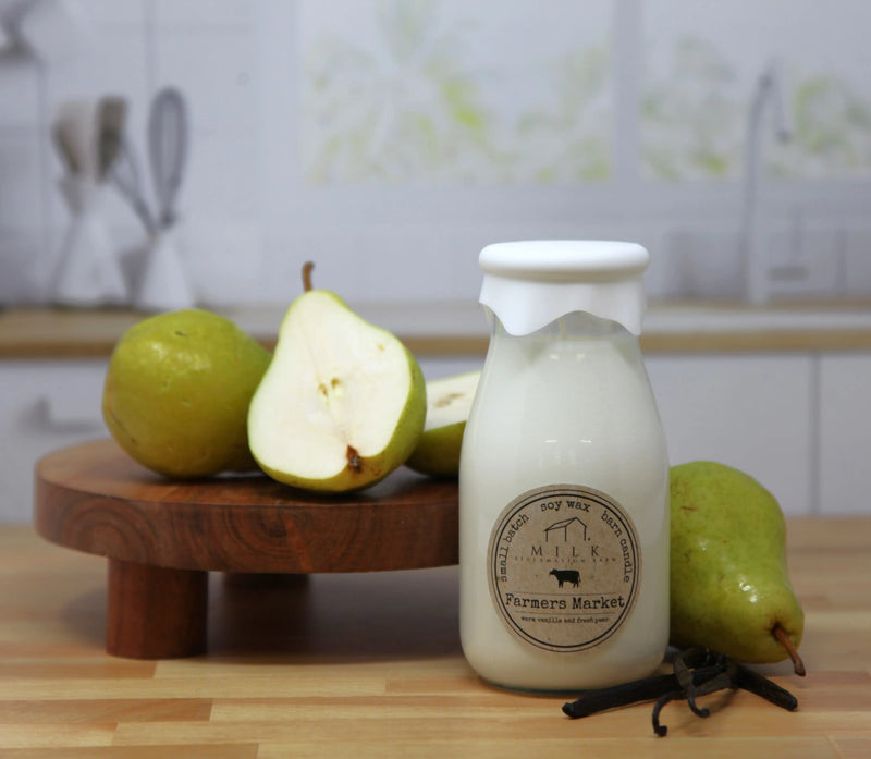 Glass bottle labeled 'Farmers Market' with pears on a wooden surface