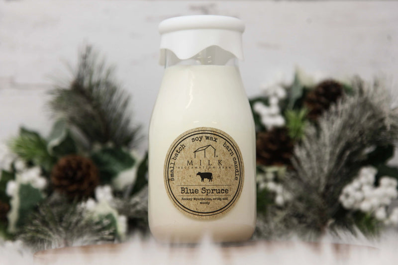 Bottle of 'Blue Spruce' candle with a label on a decorative background