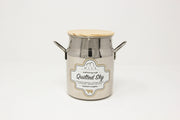 Metal milk churn with wooden lid on a white background