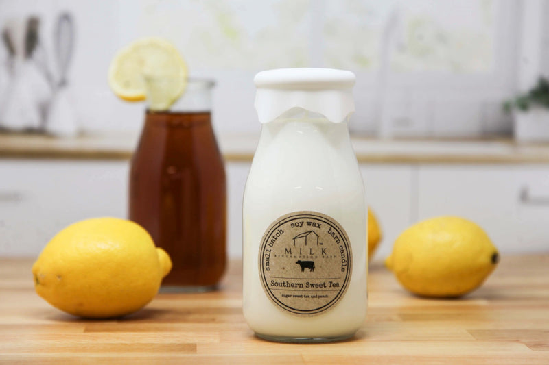 Milk bottle with a label on a wooden surface with lemons and a jar of honey in the background.