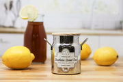 Jar of 'Southern Sweet Tea' with lemons and a bottle of tea in the background on a wooden surface.