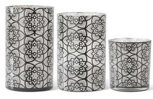 Set of three black and white patterned candle holders on a white background