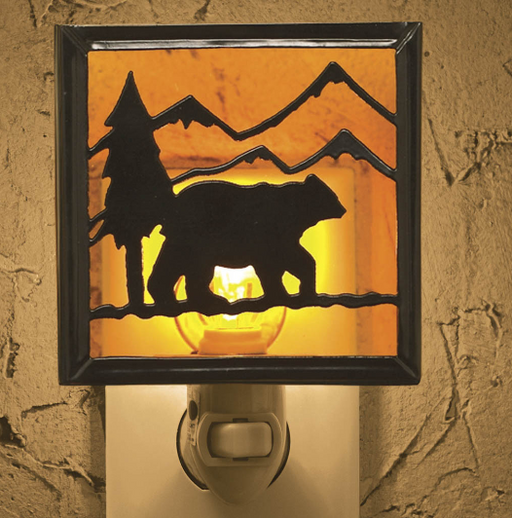 Night light with bear and mountain design on a textured wall.