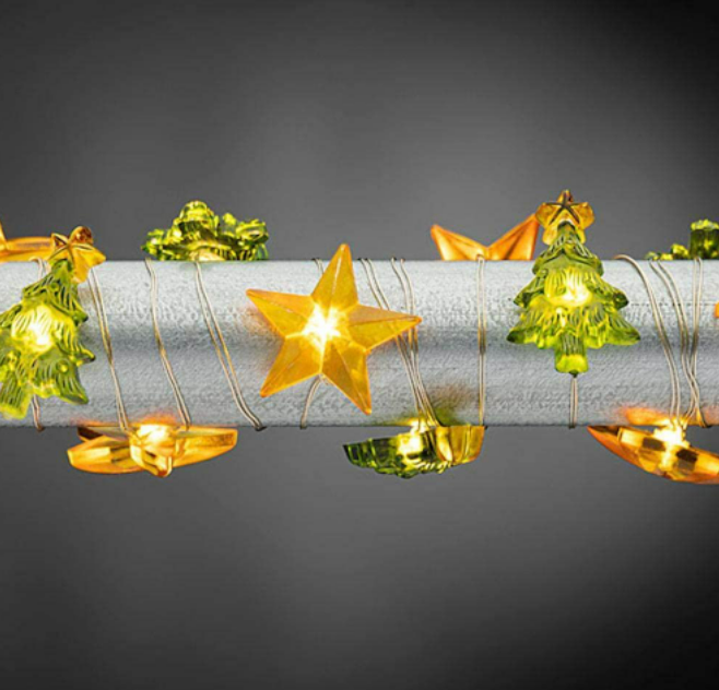 Decorative string lights with star, tree, and bow shapes on a dark background