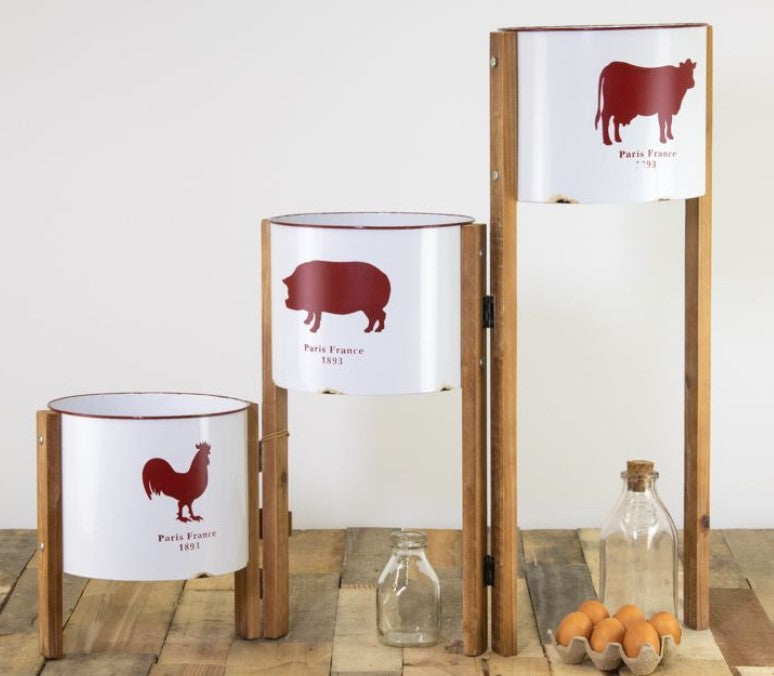 Set of three cylindrical containers with animal illustrations on lids, placed on a wooden surface.