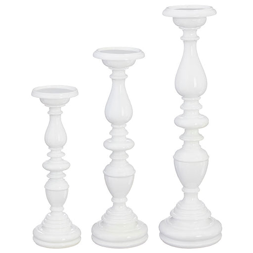 Three white candle holders of different heights on a white background